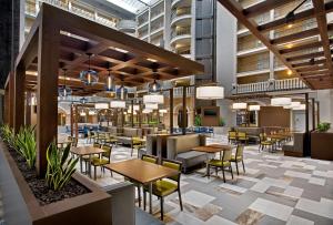 奥兰多奥兰多国际大道会展中心希尔顿合博套房酒店的餐厅的 ⁇ 染,配有桌椅