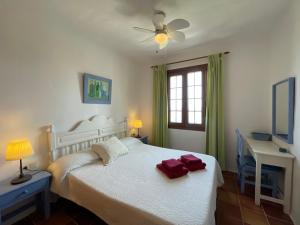 福尔内利斯BERGANTIN 109 by SOM Menorca的卧室配有白色的床和吊扇