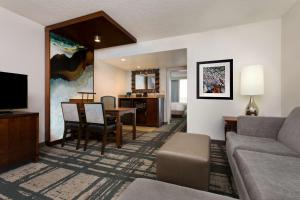 奥兰多奥兰多国际大道会展中心希尔顿合博套房酒店的带沙发的客厅和用餐室