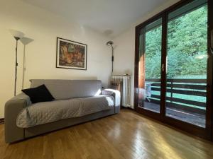 Giustino026 Bilocale con caminetto, Giustino的带沙发和滑动玻璃门的客厅