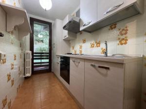 Giustino026 Bilocale con caminetto, Giustino的厨房配有白色橱柜和水槽