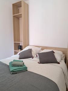 昂代Appartement proche plage hendaye的一张带两个枕头的床和两条毛巾