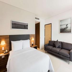 坎昆坎昆孔布雷斯希尔顿汉普顿酒店的一间卧室配有一张大床和一张沙发
