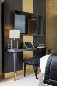 巴黎尼皮斯巴黎希尔顿Curio Collection酒店的一张桌子,一张笔记本电脑和一把椅子放在房间里