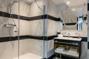 巴黎尼皮斯巴黎希尔顿Curio Collection酒店的带淋浴和盥洗盆的浴室