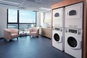 普崇Hilton Garden Inn Puchong的洗衣房配有2台洗衣机和烘干机