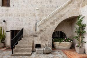 阿雷基帕Hampton by Hilton Arequipa的石头建筑,有楼梯和一盆鲜花