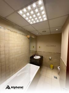 迪拜Alphatel Beach Hostel JBR的一间带大浴缸和水槽的浴室