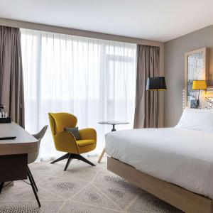 图尔Hilton Garden Inn Tours Centre, France的酒店客房配有一张床、一把椅子和一张书桌