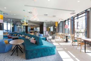 BaliceHampton by Hilton Krakow Airport的大堂设有蓝色的沙发和桌椅