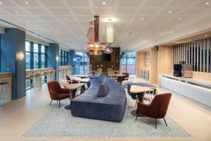 罗奇代尔Hampton By Hilton Rochdale的大堂设有蓝色的沙发和桌椅