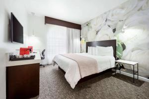 洛杉矶O Hotel by LuxUrban的一间卧室配有一张大床和一个大花壁画