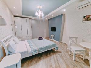 基辅Real Home Apartmens - Podil Promenade的卧室配有1张床、1张桌子和1把椅子