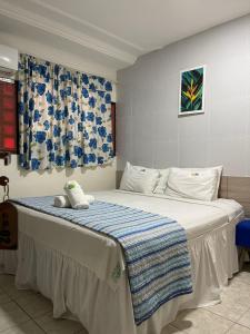 若昂佩索阿卡博布兰科酒店的一间卧室配有一张带蓝白色毯子的床