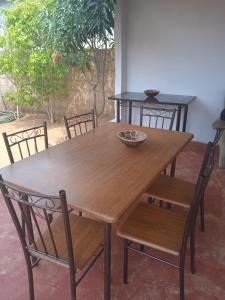 卡萨内Sunshinevibe guest house的木桌和椅子,顶上放碗