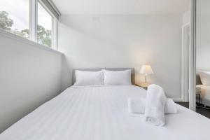 墨尔本Bright and Modern Space with a Balcony and Parking的白色的卧室设有白色的床和窗户。