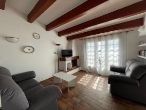 福尔内利斯ES CASTELL 1 by SOM Menorca的客厅设有两张沙发和墙上的时钟