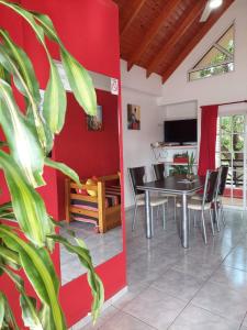 埃利萨镇AltoRojo的一间设有红色墙壁和桌椅的用餐室