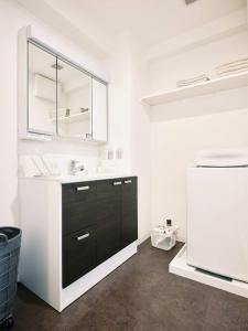 熊本intro vetta 1003 Free parking的厨房配有水槽、镜子和冰箱