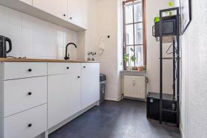 杜伊斯堡NEXT HOME - FREE Parking & WiFi - Badewanne的厨房配有白色橱柜和水槽