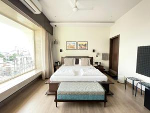 加尔各答城中心住宿加早餐旅馆的一间卧室设有一张大床和一个大窗户