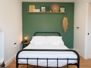 伦敦Pass the Keys - Beautiful designer Maisonette with Garden and BBQ的一间卧室配有一张带绿色墙壁的床
