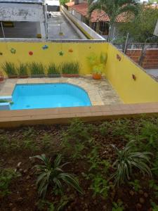 若昂佩索阿Pousada Aconchego do Tambaú的一座游泳池,位于一个黄色的院子内