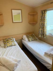 纽基Newquay Bay Porth Caravan - 8 Berth的小型客房 - 带2张床和窗户