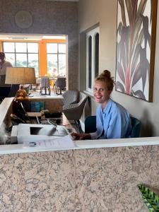 滨海索尔特本Spa酒店的坐在办公室桌子上的女人