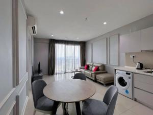 莎阿南Comfy Staycation 4PX with Free Parking, Direct Linked SOGO & Central I-CITY的厨房以及带桌椅的起居室。