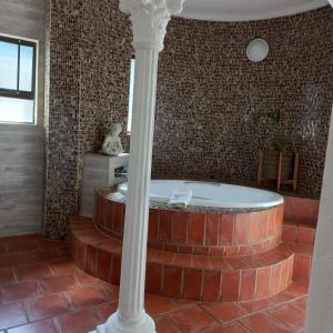 马盖特Beachcomber Bay Guest House In South Africa的砖墙客房内的浴缸