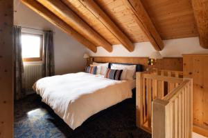切勒里纳凯萨罗萨兹酒店 - 食物之家的卧室设有白色大床和木制天花板。