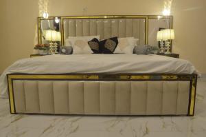 卡拉奇Charming Home banglow的一张带金属框架和枕头的大床