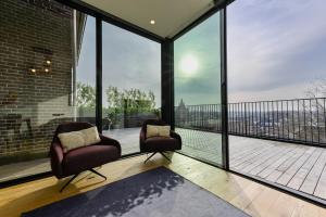 奥斯特韦克12A, Luxe & Uniek - Bioscoopzaal - Terras - Uitzicht的两把椅子坐在带大窗户的阳台