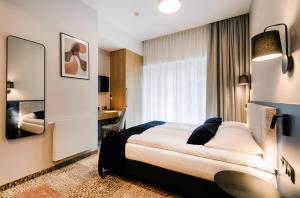 格但斯克Hotel Vesper House的配有一张床和一张书桌的酒店客房