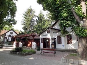 米什科尔茨Talizmán Étterem Panzió的前面有长凳的建筑