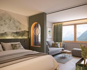 上陶恩Hotel Römerhof Superior的一间卧室配有一张床、一张沙发和一个窗口