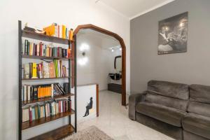 都灵MM Bengasi Modern Apartment的客厅配有沙发和带书籍的书架