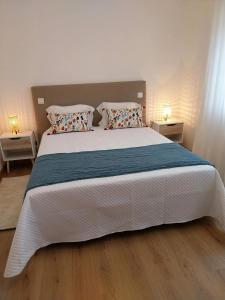 法蒂玛Casa com ALma的卧室配有一张带两个枕头的大白色床