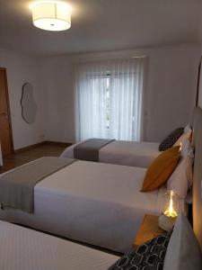 法蒂玛Casa com ALma的酒店客房设有两张床和窗户。