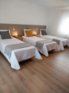 法蒂玛Casa com ALma的木地板客房内的一排床