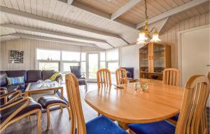 BrejningBeautiful Home In Brkop With 3 Bedrooms, Sauna And Wifi的一间带木桌和椅子的用餐室