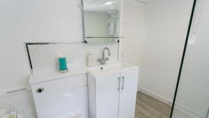 罗斯奈格尔Borth Bach的白色的浴室设有水槽和镜子