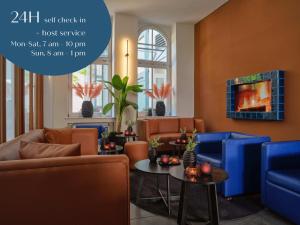 科隆Classik Hotel Antonius的客厅配有蓝色的椅子和桌子