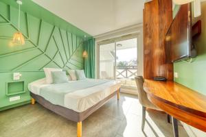 圣吉尔莱班热带公寓酒店的一间卧室配有一张床、一张桌子和一个窗户。