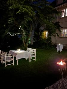 阿斯克尔Øvre Sem Gård的夜晚在院子里的一张白色桌子和椅子