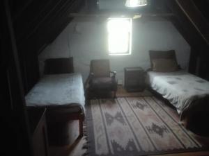 Mount PleasantEmerald Hill Cottage的一间设有两张床和窗户的黑暗客房