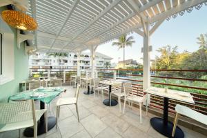 圣吉尔莱班热带公寓酒店的餐厅的露台,配有桌椅