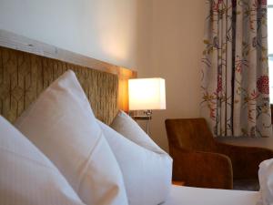 布莱特瑙Feriengasthof Löwen的酒店的客房 - 带白色枕头和椅子的床