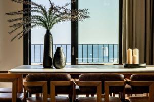 依拉佩特拉Beach Villas in Crete - Alope & Ava member of Pelagaios Villas的餐桌、椅子和大窗户